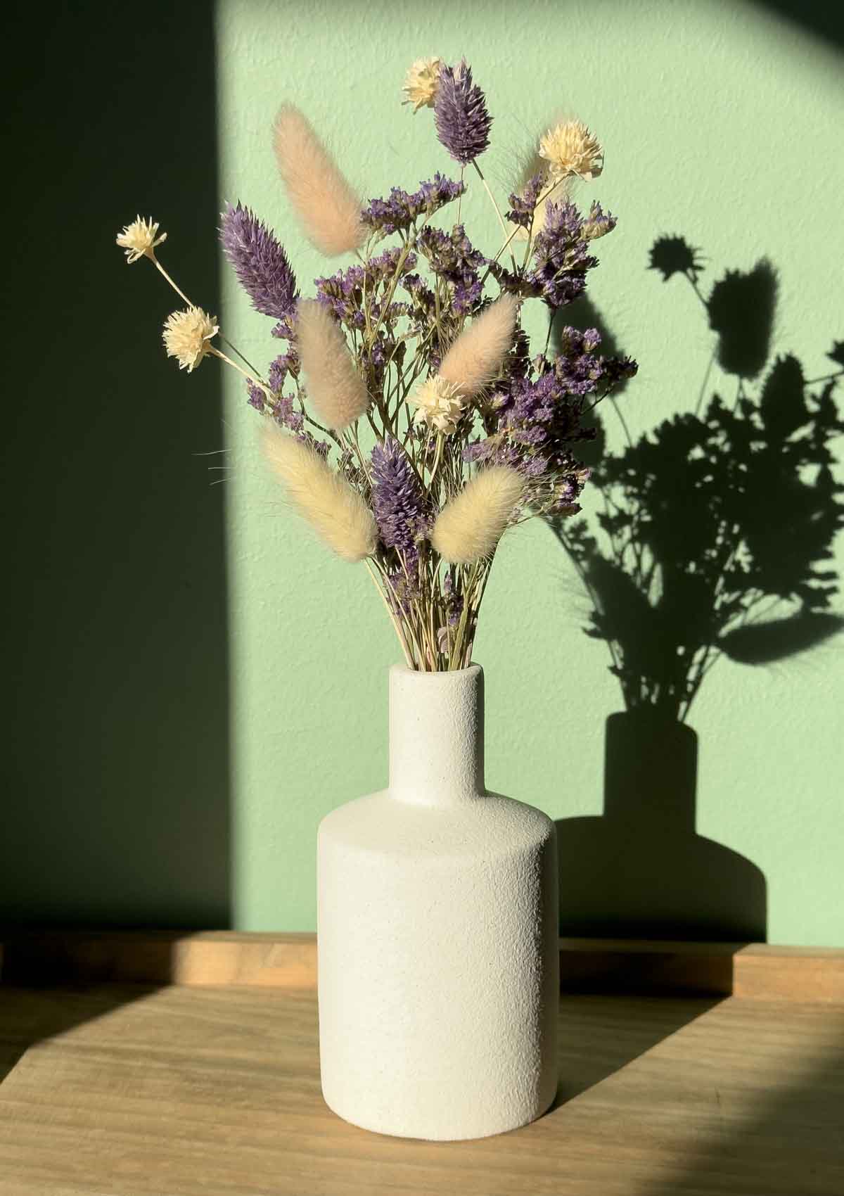 Kleine zylindrische Vase in Weiß – perfekt für einen kleinen Trockenblumenstrauß, einzelnen Blumen oder Gräser. Ihr minimalistisches Design passt auch in kleine Ecken und bringt filigrane Blüten toll zur Geltung.