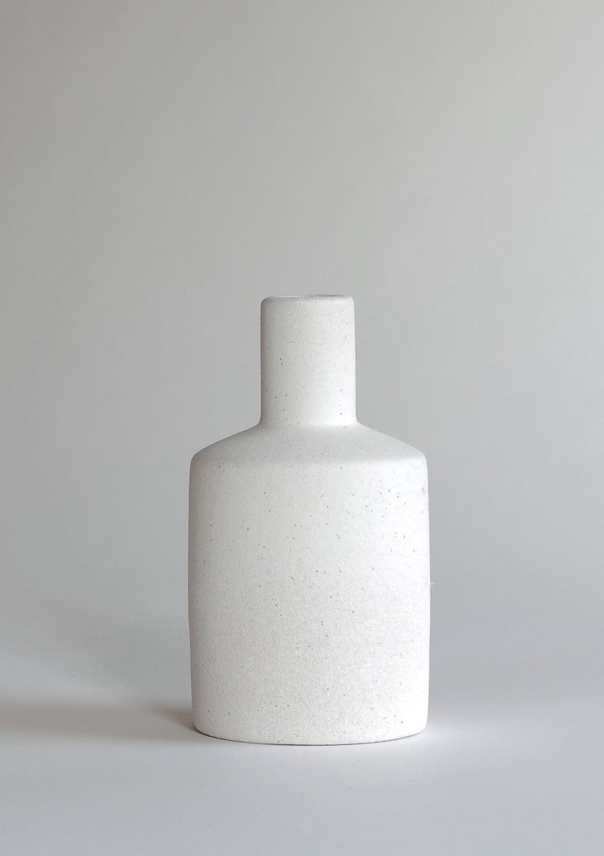 Kleine, gerade Keramikvase in Weiß – schlankes, zylinderförmiges Gefäß, ideal um einzelne Trockenblumen oder einen schlanken Blütenstiel elegant zu präsentieren.
