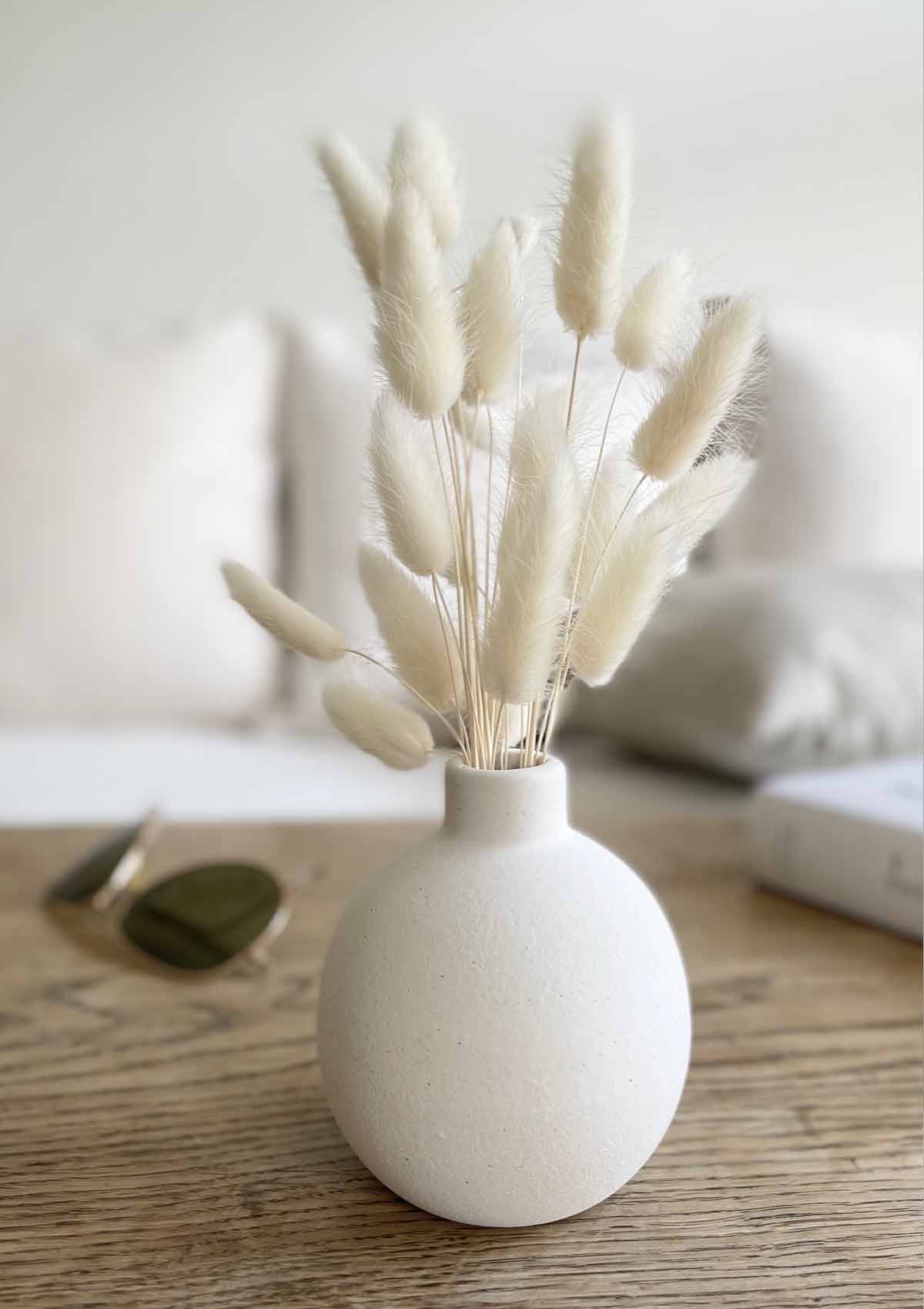Kleine runde Keramikvase in Weiß – schlichtes, kugelförmiges Design. Perfekt als Vase für ein kleines Bund Lagurus Trockenblumen in der Farbe creme-weiss.