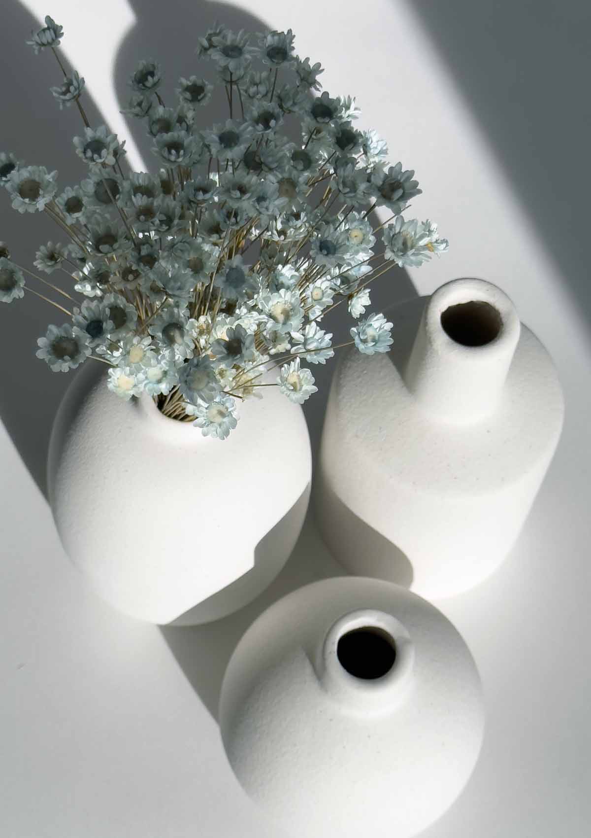 Trio von drei kleinen weißen Keramikvasen (oval, rund, gerade) – dekoratives Set, vielfältig arrangierbar, ideal für einzelne Trockenblumen oder Mini-Sträuße.